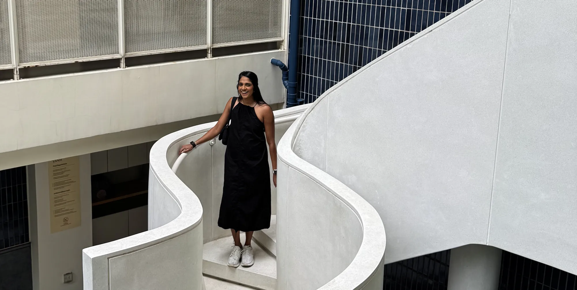 Adele standing on a curved white staircase